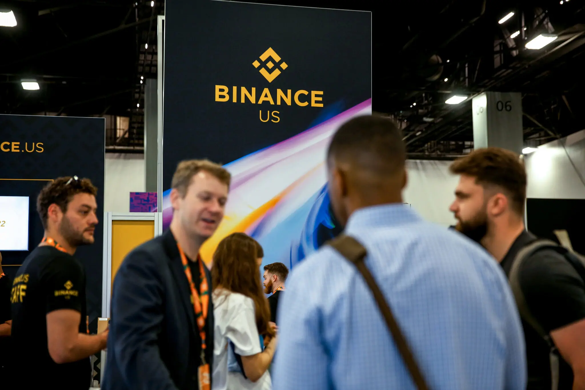 Attendees at a Binance US booth during a cryptocurrency conference